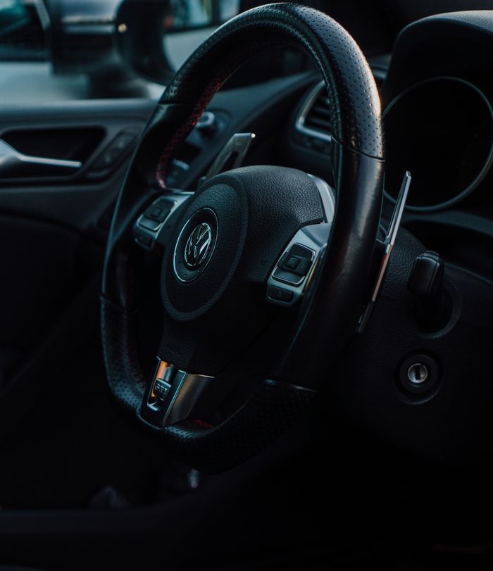 Detailed view of a car steering wheel in a Volkswagen interior with modern design elements.