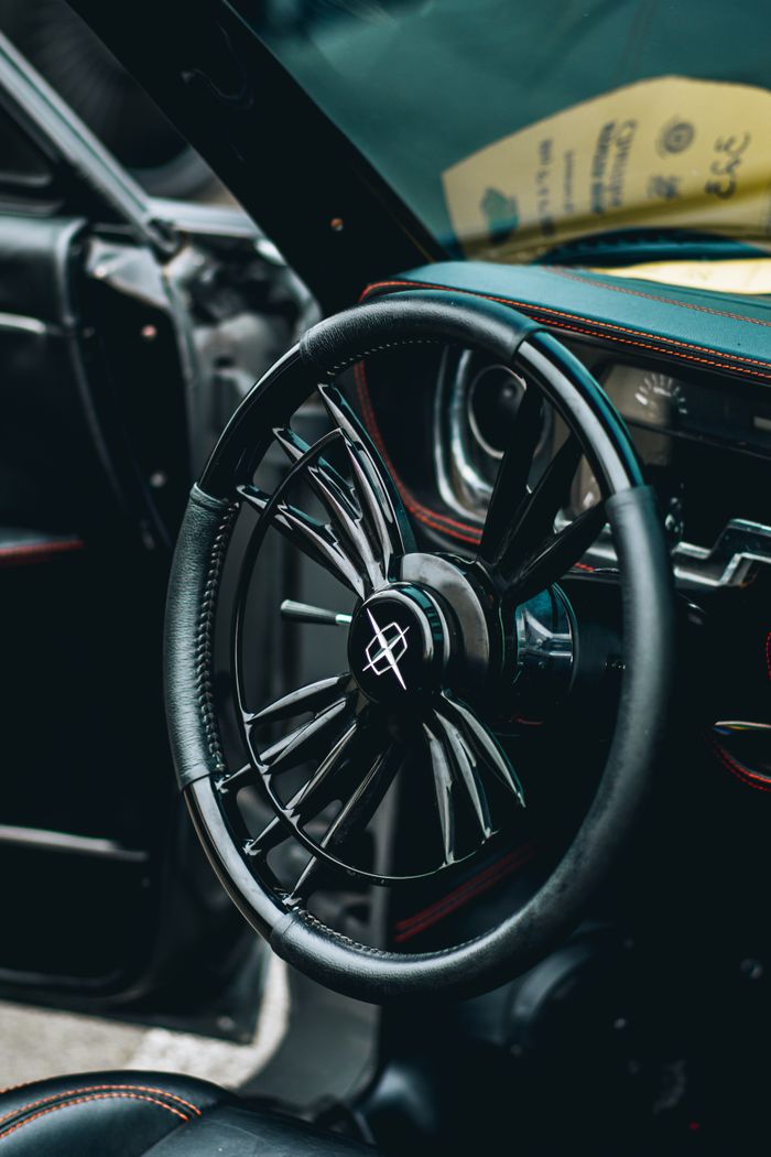 Detailed view of a sleek, modern car steering wheel with black leather accents.